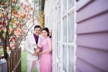 Photo of Couple Standing Beside a Wall