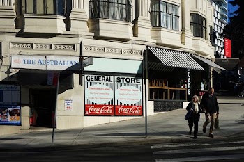 photo of couple walking on road near store