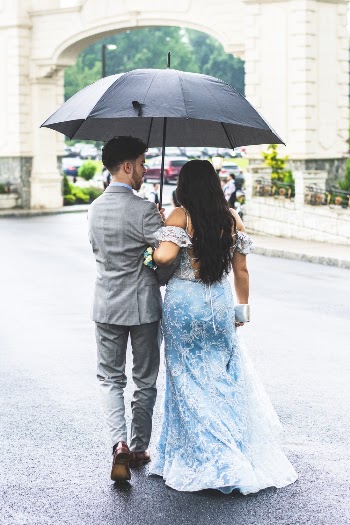 Photo of Couple Walking Under Umbrella