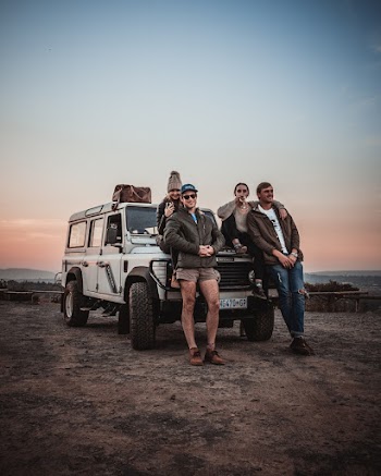 Photo of Couples Smiling While Leaning on Vehicle