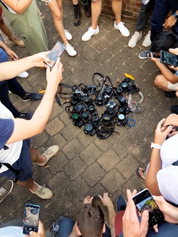 Photo of DSLR Cameras Lying on the Ground Surrounded by People