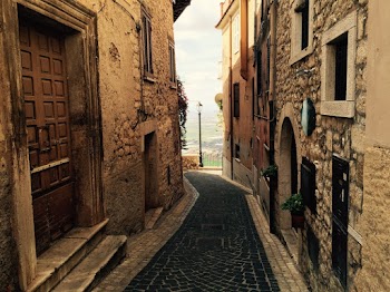 Photo of Empty Alley In Between Brown Concrete Buildings