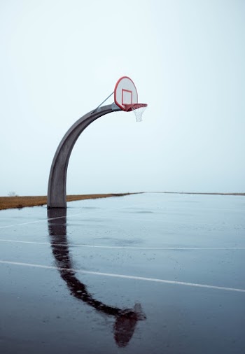 Photo of Empty Concrete Basketball Court on Gloomy Day