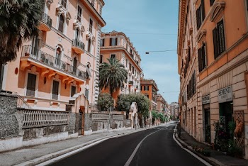 Photo of Empty Road In Between Orange Concrete Buildings Under Clear Blue Sky