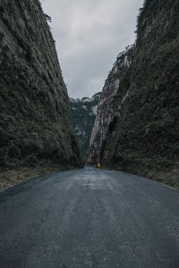 Photo of Empty Road In Between Rocky Hills