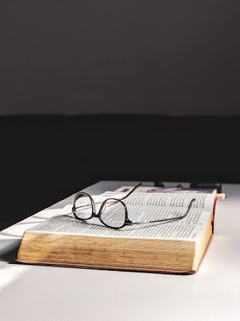 Photo Of Eyeglasses On Top Of The Book