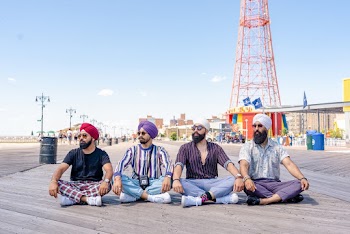 Photo of Four Men Sitting on Boardwalk