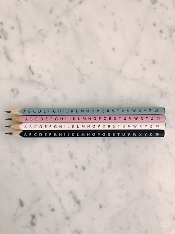Photo of Four Pencils on Marble Tiles