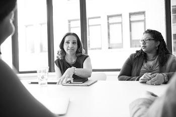 Photo of Four People Having Conversation in Room