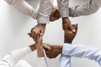 Photo of Four Persons Uniting Hands