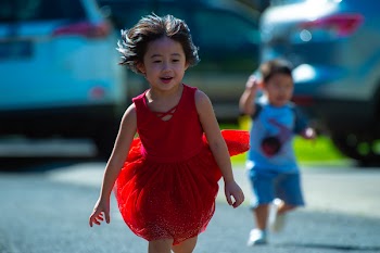 Photo of Girl in Red Dress Running on Street