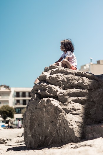 Photo Of Girl Sitting On Top Of The Rock