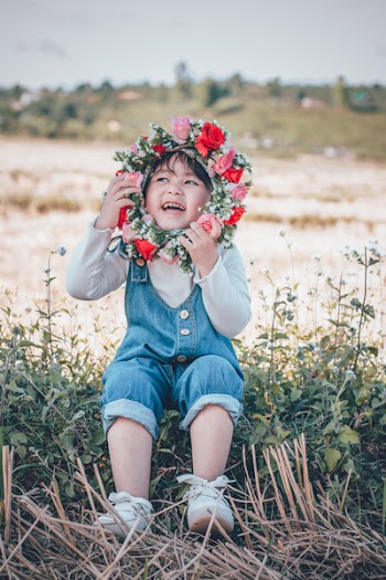 Photo of Girl Sitting While Holding Flower Headband