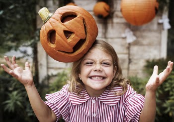 Photo of Girl Smiling With Jack-o'-lantern on Her Head