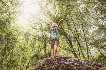 Photo of Girl Standing on Rock Raising Her Hands