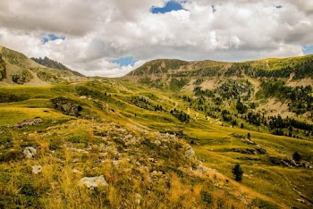 Photo of Grass Field and Mountain Under Cloudy Sky