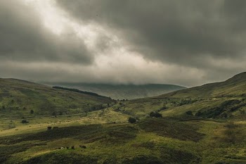 photo of green mountain under white sky at daytime