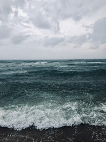 Photo of green sea under cloudy sky