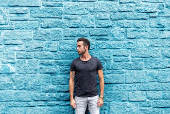 Photo of Guy Standing In Front Of Blue Wall