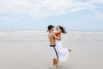 Photo of Happy Couple Hugging on the Beach