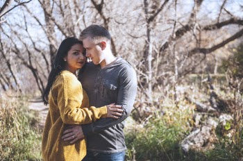 Photo of Hugging Couple Standing In Front of Bare Trees