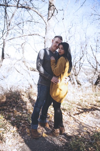 Photo of Hugging Couple Standing In Front of Bare Trees
