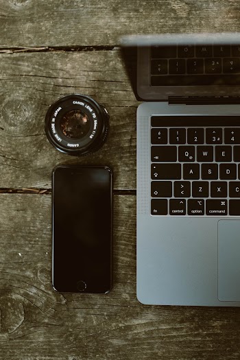 Photo of Iphone 6 and Camera Lens Beside Macbook