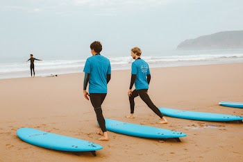 Photo of Male Surfers Stretching on the Beach