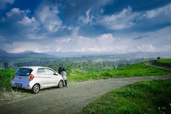 Photo of Man and Woman Beside Gray 5-door Hatchback