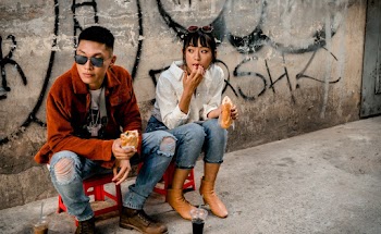 Photo of Man and Woman Eating While Sitting