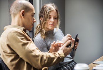 Photo of Man and Woman Holding Smartphones