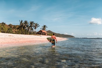 Photo of Man Carrying Surfboard