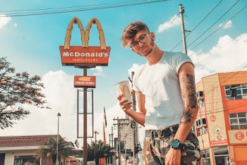 Photo of Man Holding a McDonald's Paper Cup