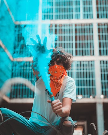 Photo of Man Holding Blue Smoke Bomb