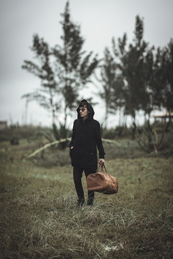 Photo Of Man Holding Brown Duffel Bag