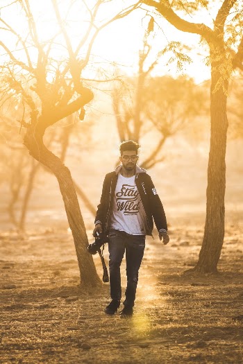 Photo of Man Holding Digital Camera While Walking
