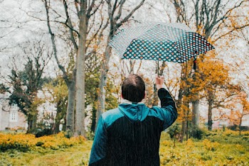 Photo of Man Holding Umbrella While Raining