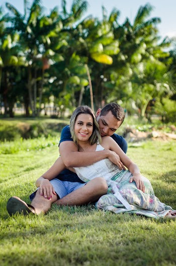 Photo of Man Hugging Woman While Siting on Green Grass 