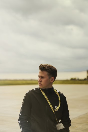 Photo of Man in Black Jacket Wearing Yellow Lanyard Looking Away
