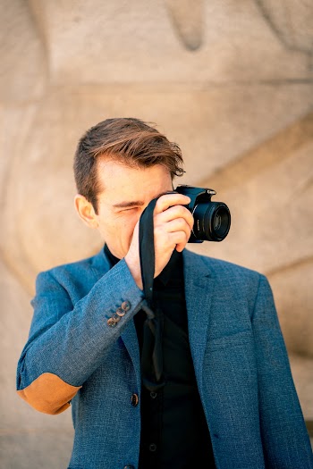 Photo of Man in Black Shirt and Blue Blazer Taking a Photo