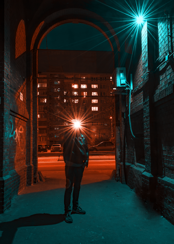 Photo of Man in Jacket Standing in Alley
