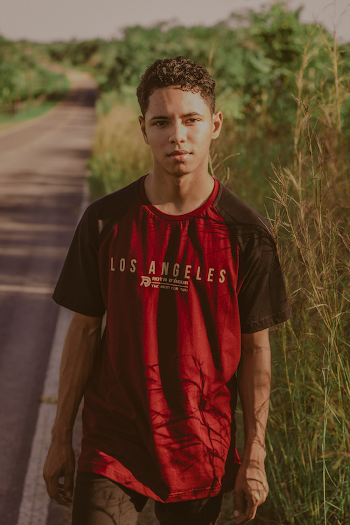 Photo of Man in Red and Black Crew-neck T-shirt Posing By Roadside