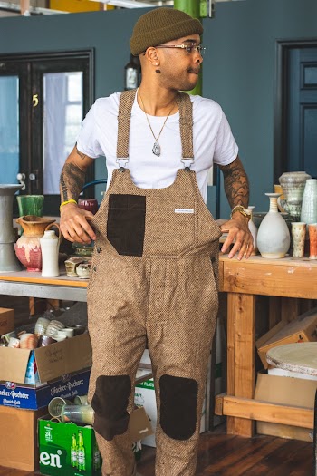 Photo of Man In Tweed Dungarees Standing Near Table Looking Away