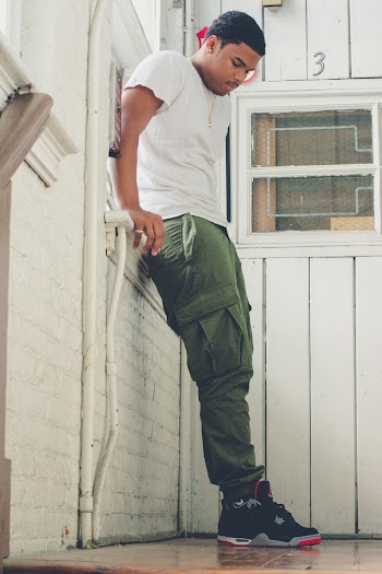Photo of Man in White Shirt Leaning on Wall