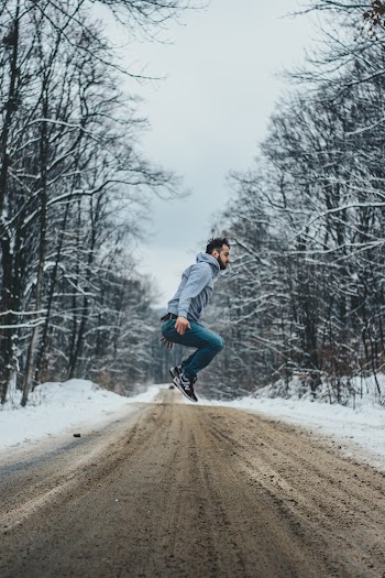 Photo of Man Jumping on Dirt Road
