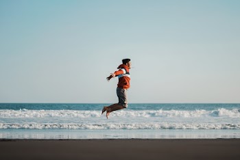Photo of Man Jumping on Seashore