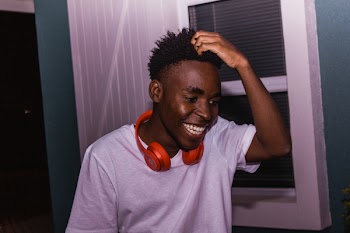 Photo of Man Laughing While Scratching His Head