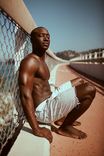 Photo of Man Leaning on Cyclone Fence