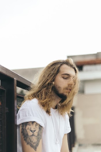 Photo of Man Leaning On Fence