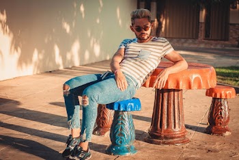 Photo of Man Leaning on Orange Concrete Table